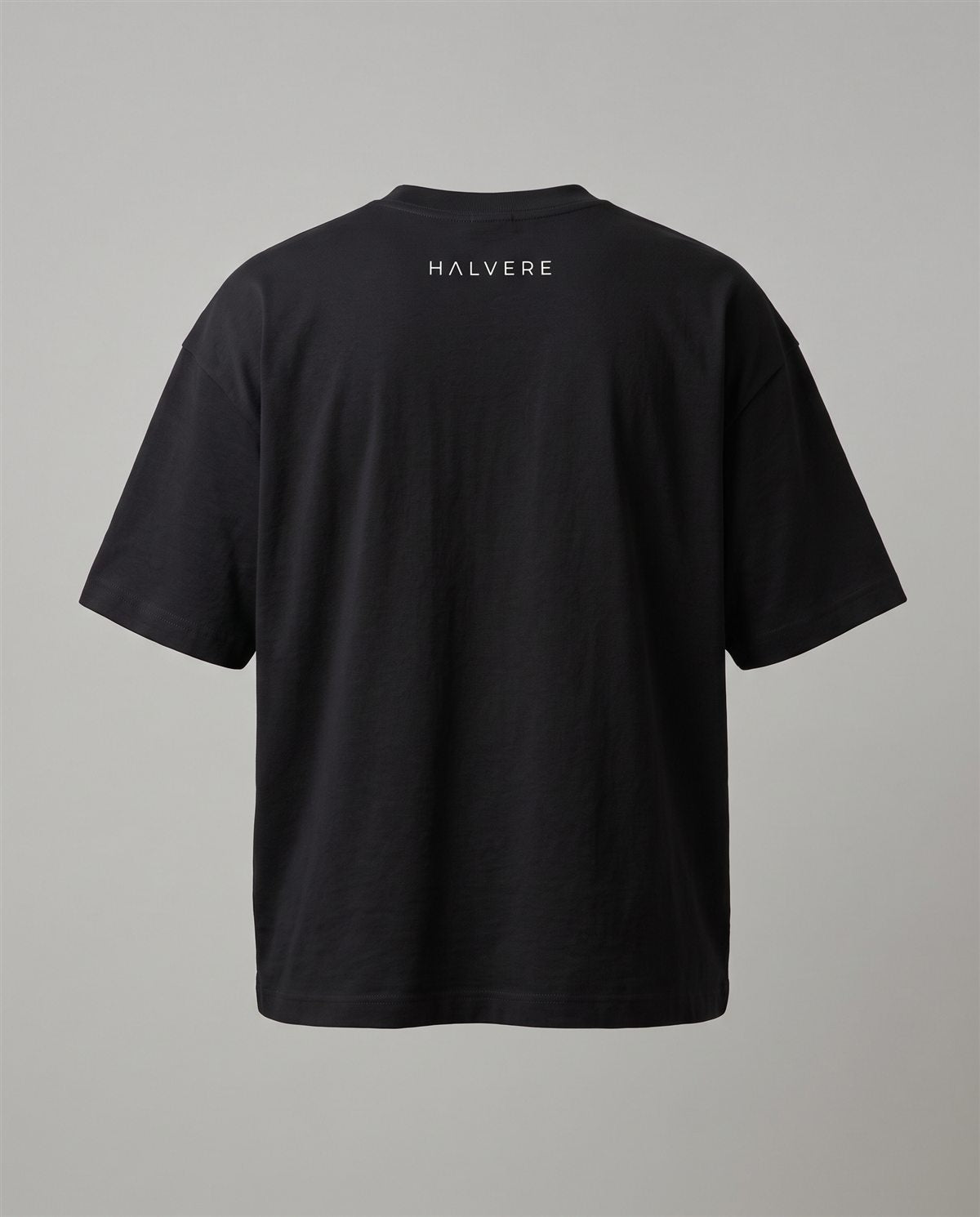 HALVERE oversized tee in black, back view with the HALVERE wordmark below the collar