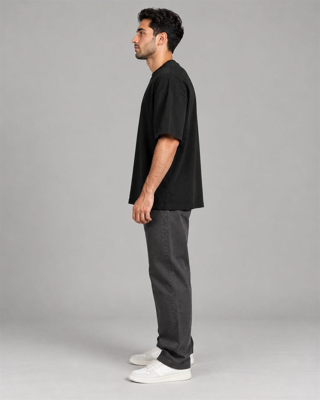Side view of the black HALVERE oversized tee showing the dropped shoulder